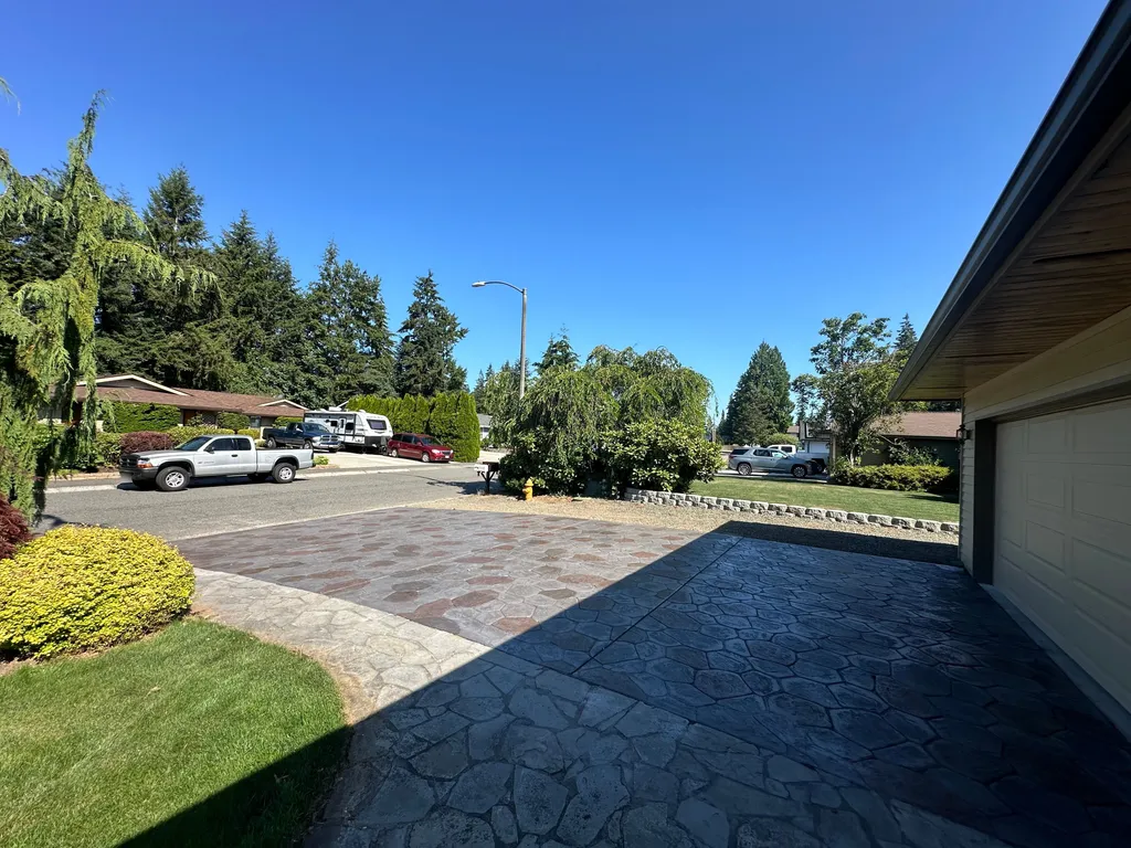 Two tone stamped concrete driveway in a stone pattern, viewed from the garage toward the street